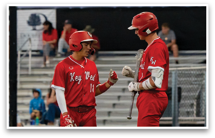 Two baseball players wearing red uniforms shake hands on the field. AI generated content