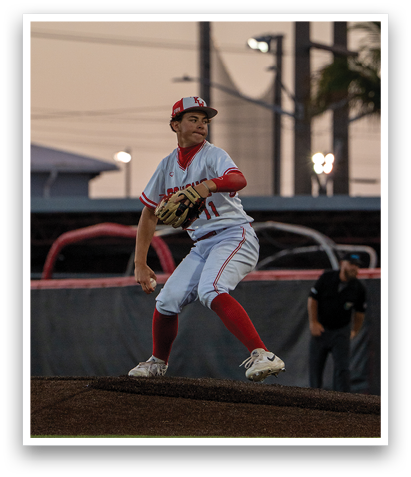 A baseball player in a white and red uniform is pitching a ball on a field. AI generated content