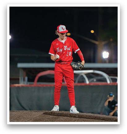 A baseball player in a red uniform stands on a mound, holding a baseball glove. AI generated content
