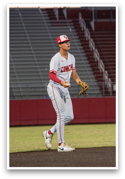 A baseball player wearing a red and white uniform stands on a field. AI generated content