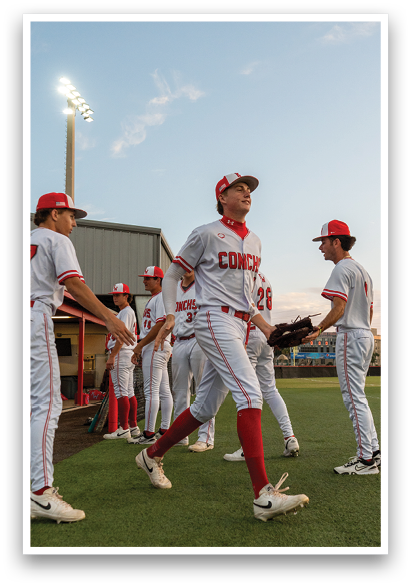 A group of baseball players wearing red and white uniforms are walking on a field. AI generated content