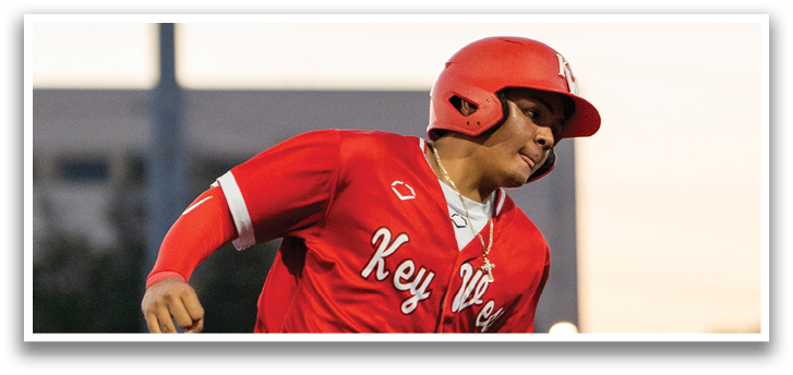 A baseball player in a red uniform running on a field. Description generated by AI