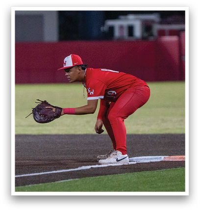 A baseball player in a red jersey and red pants is running towards home plate. Description generated by AI