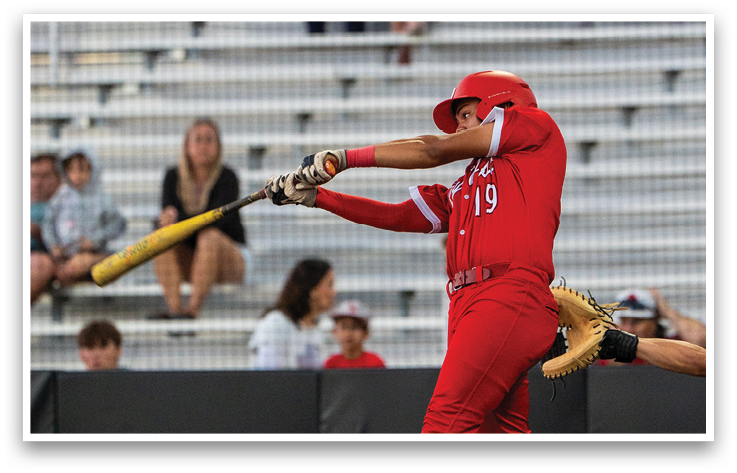 A baseball player in a red shirt and white shoes is swinging a bat. Description generated by AI