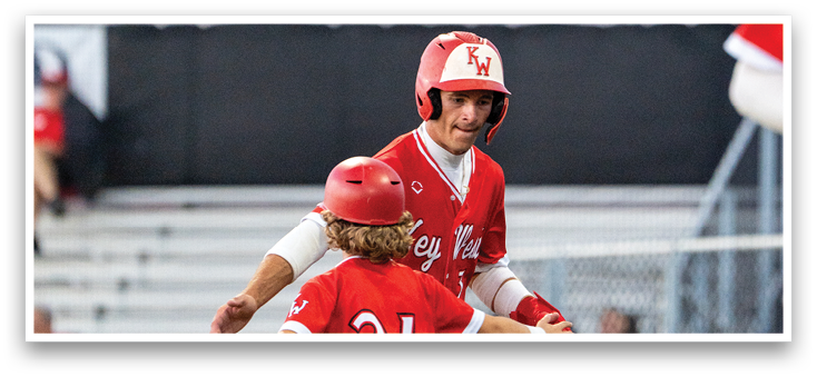 A boy in a red jersey is hugging a man in a red jersey. Description generated by AI