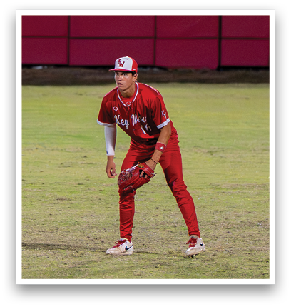 A baseball player in a red jersey and red pants is running towards home plate. Description generated by AI