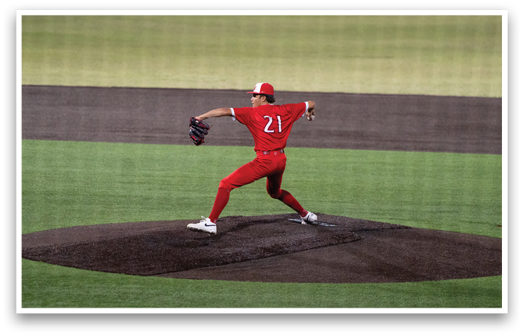 A baseball player in a red shirt and white shoes is swinging a bat. Description generated by AI