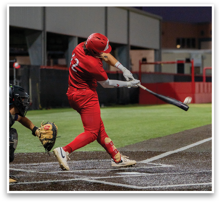 A baseball player in a red uniform is standing on a field. Description generated by AI