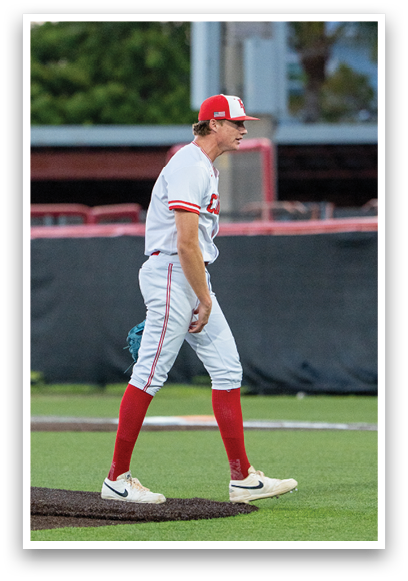 A baseball player wearing a red and white uniform. Description generated by AI