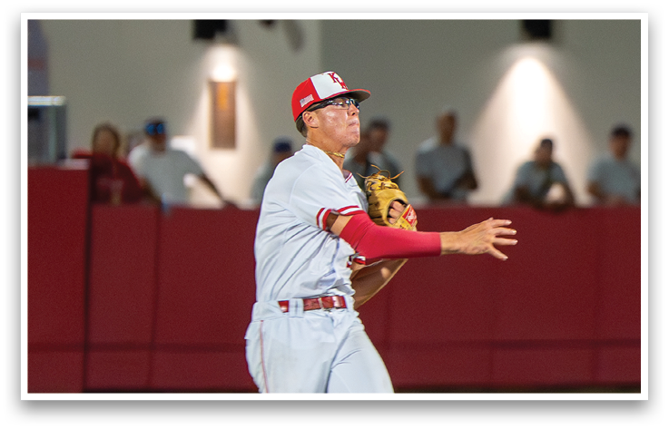 A baseball player wearing a red and white uniform is jumping in the air to catch a ball. Description generated by AI