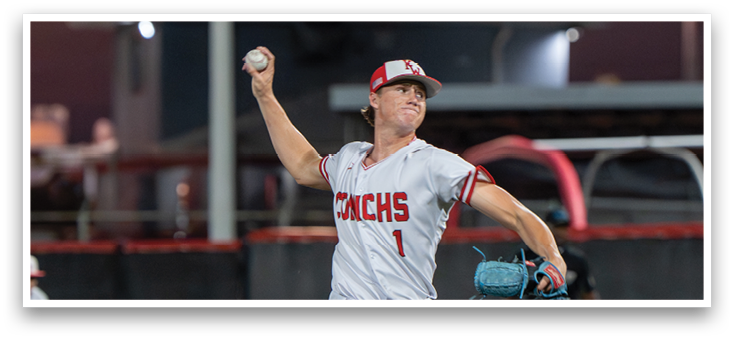 A baseball player in a white uniform is pitching a ball. Description generated by AI