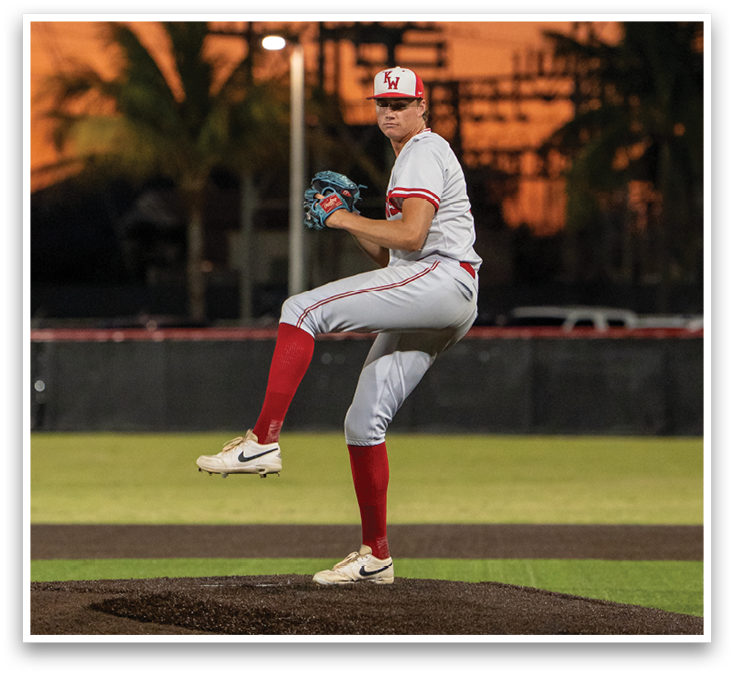 A baseball player in a white uniform with red socks and a red hat. Description generated by AI