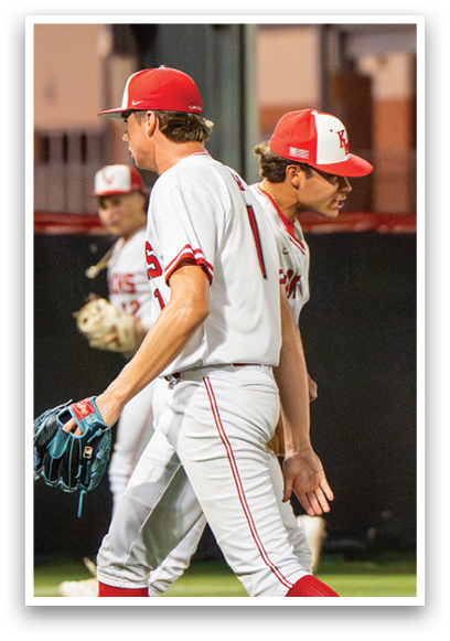 Two baseball players wearing red and white uniforms. Description generated by AI