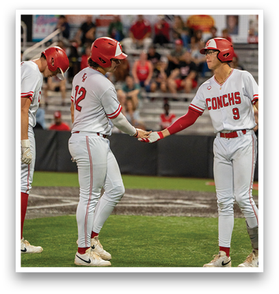 A baseball player wearing a red helmet shakes hands with another player. Description generated by AI