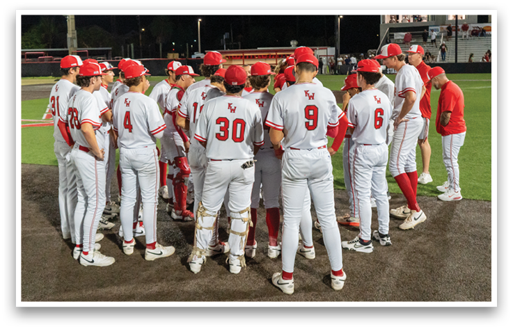 A group of baseball players wearing red and white uniforms. Description generated by AI