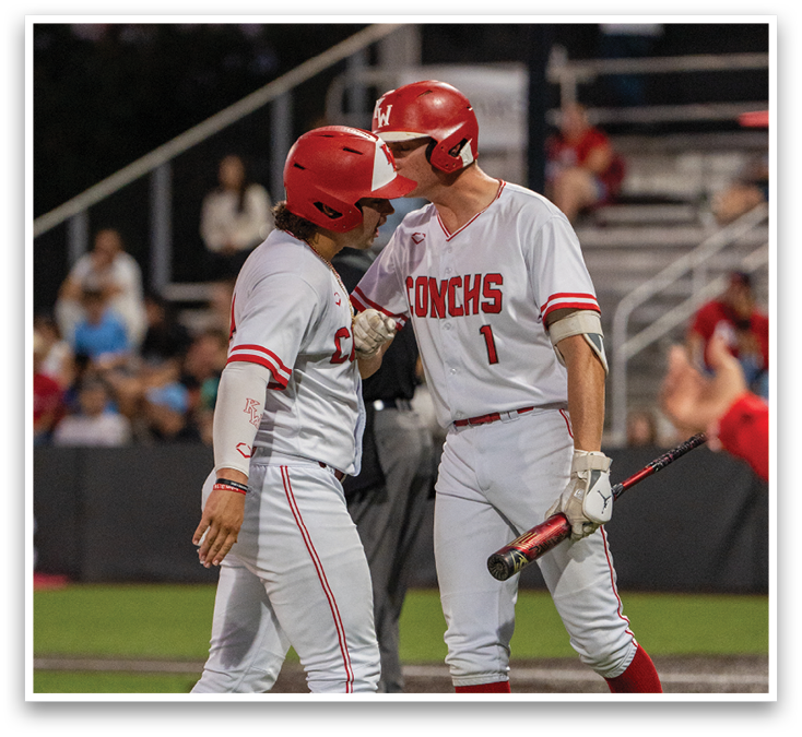 Two baseball players wearing red and white uniforms. Description generated by AI