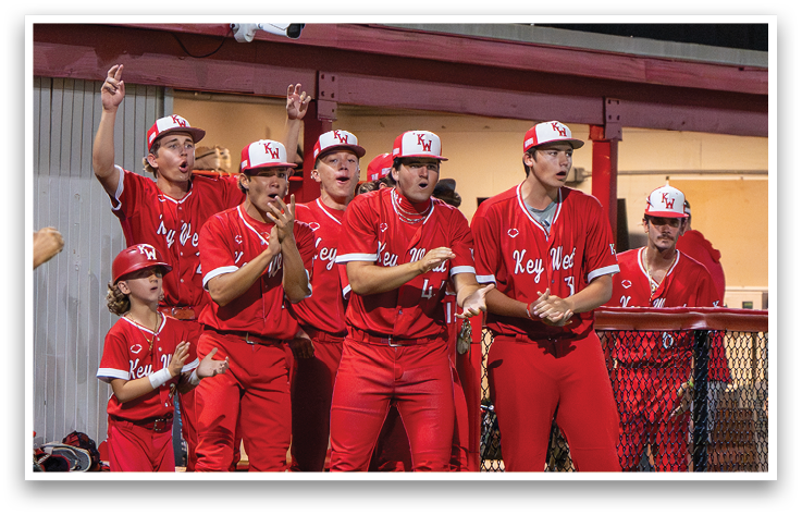 A group of men wearing red jerseys and red pants. Description generated by AI