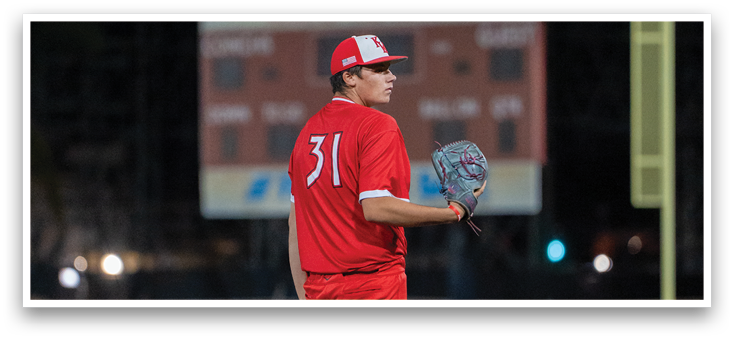 A man in a red baseball uniform is on the pitcher's mound. Description generated by AI