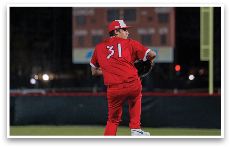 A baseball player in a red uniform is pitching a ball. Description generated by AI