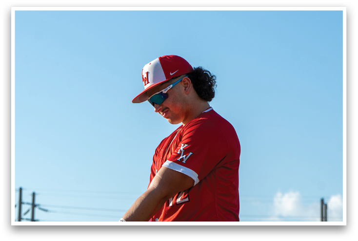 A woman wearing a red baseball uniform. Description generated by AI