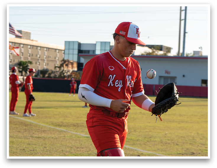 A baseball player wearing a red jersey and red pants. Description generated by AI