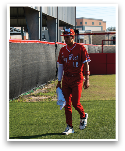 A baseball player wearing a red jersey and white pants. Description generated by AI