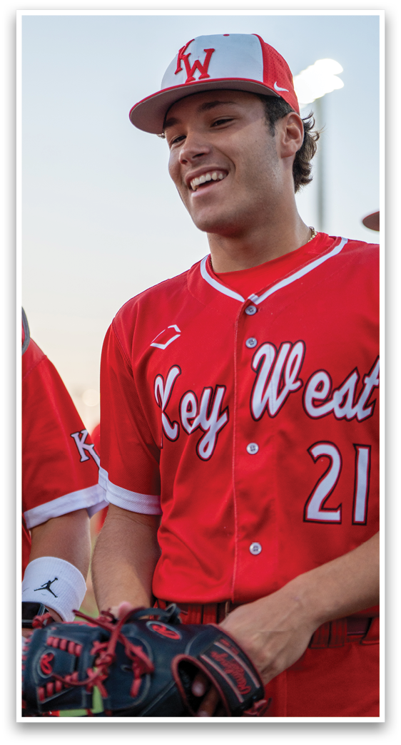 A baseball player wearing a red jersey with the number 21. Description generated by AI