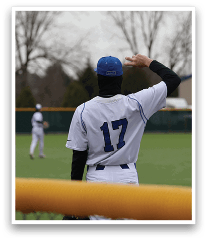 A baseball player wearing a blue and white uniform stands on a field, holding his glove up in the air. AI generated content