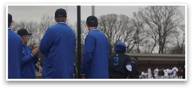 Three men wearing blue jackets are standing on a baseball field. One of them is wearing a blue hat. AI generated content