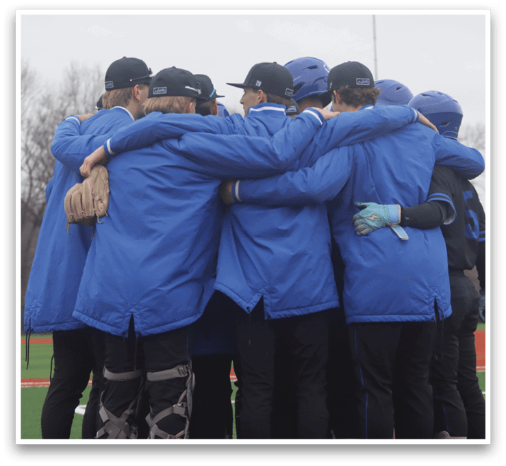 A group of people wearing blue jackets and hugging each other on a baseball field. AI generated content