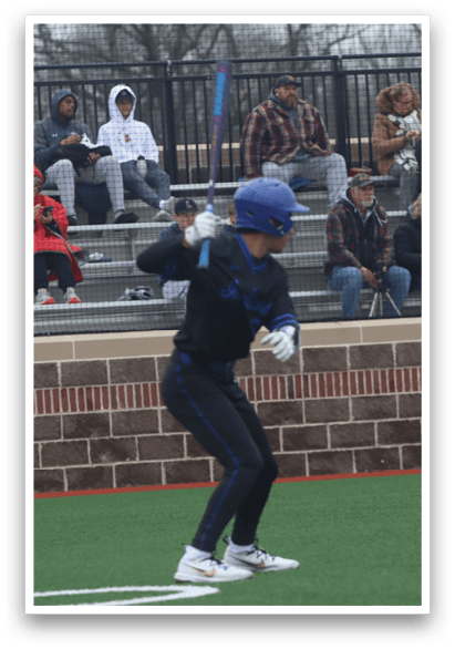 A baseball player in a blue helmet and black uniform is holding a bat, ready to hit the ball. AI generated content