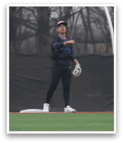 A person wearing a blue shirt and white shoes is standing on a baseball field. AI generated content