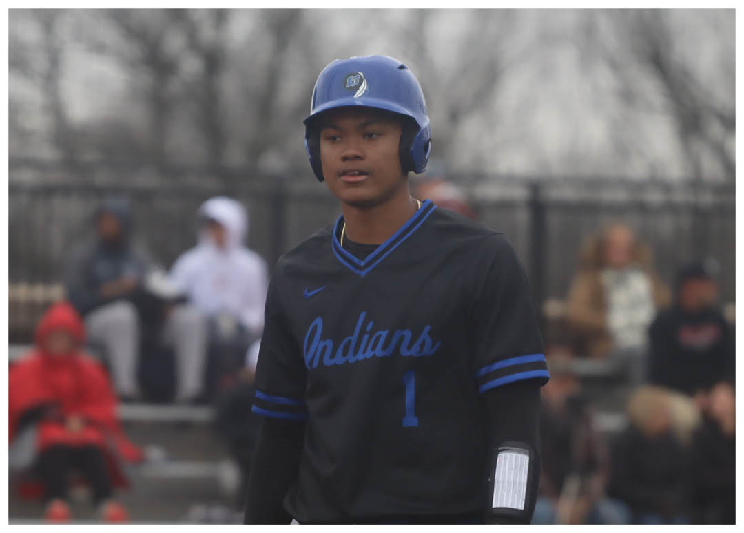 A baseball player wearing a blue helmet and black jersey stands on the field. AI generated content