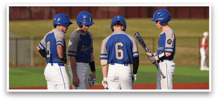 Four baseball players wearing blue and white uniforms are standing on a field, talking to each other. AI generated content