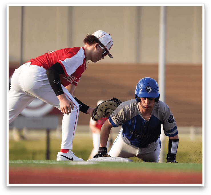 Two baseball players on a field, one wearing a red shirt and the other wearing a blue shirt. The player in the red shirt is bending over, possibly to pick up a ball. AI generated content