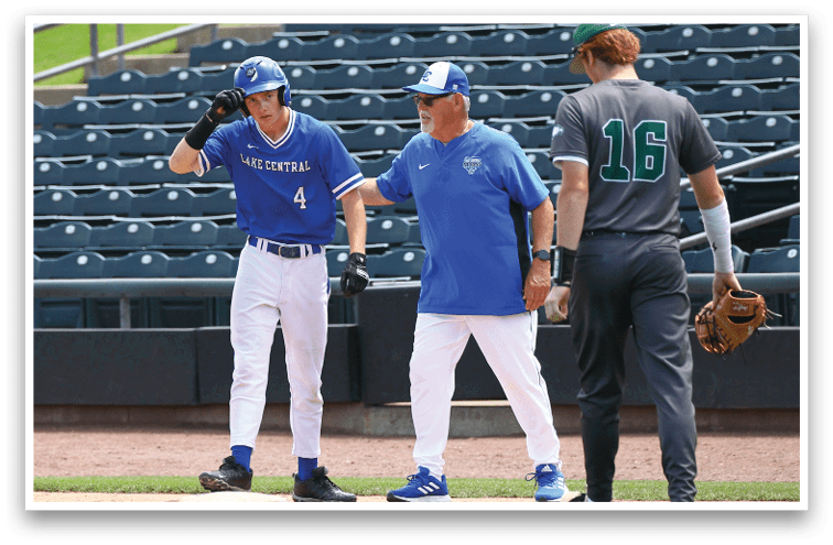 Three people in baseball uniforms stand on a field near empty stadium seats, with one person wearing a blue jersey and helmet, another in a blue shirt and white pants, and the third in a gray jersey with the number 16. Description generated by AI