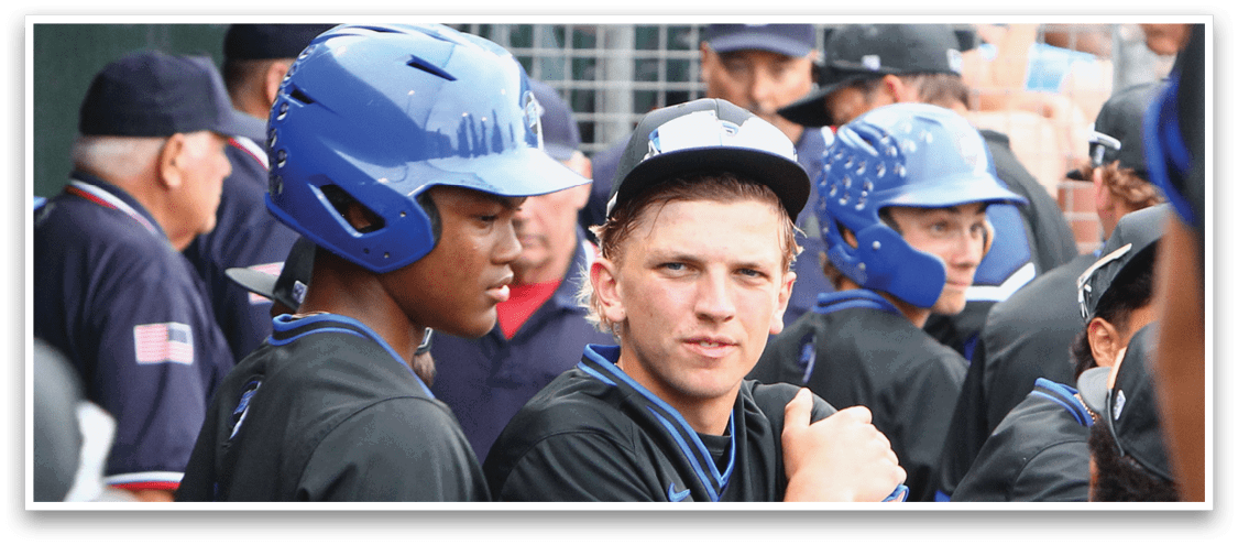 A group of people wearing sports helmets and uniforms are gathered closely together, appearing to be engaged in a team discussion or preparing for a game. Description generated by AI