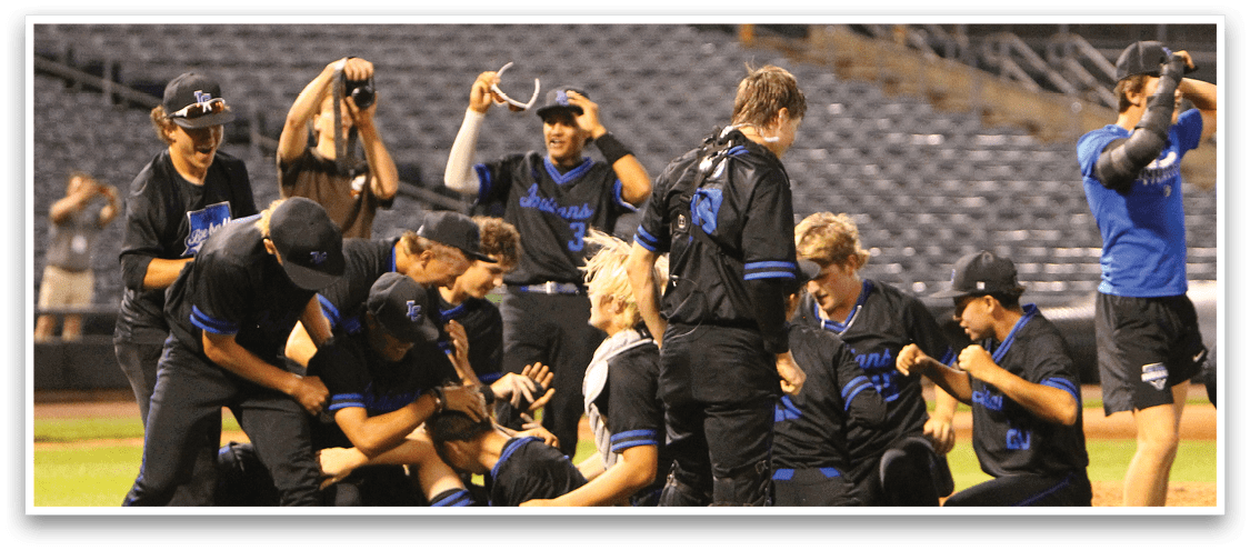A group of people wearing black sports uniforms are celebrating together on a baseball field with some kneeling and others standing. Description generated by AI