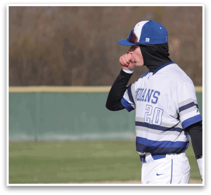 A baseball player in a white and blue uniform is holding a bat and preparing to swing at a ball. AI generated content