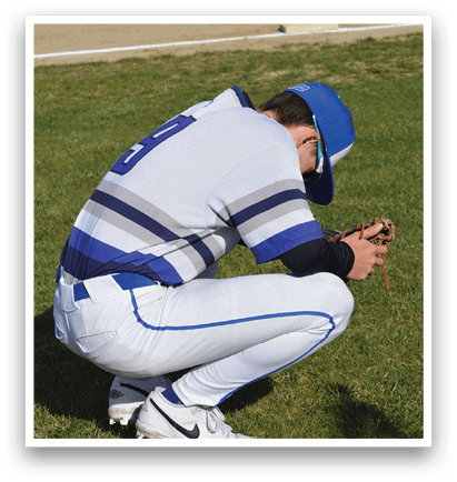 A baseball player is kneeling on the grass, looking at his cell phone. AI generated content