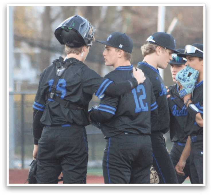 Baseball players wearing black uniforms and blue numbers huddle together on the field. AI generated content