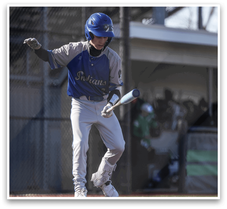 A boy in a blue and white baseball uniform is holding a bat and standing on a baseball field. AI generated content
