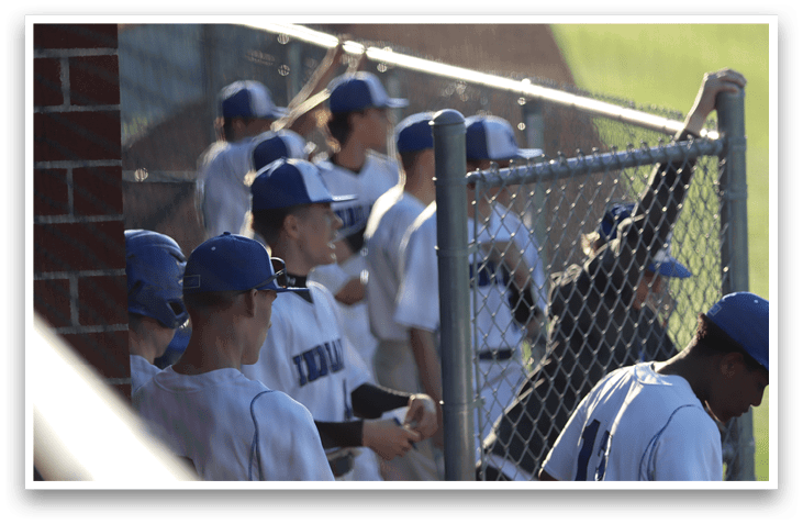 Baseball players wearing blue hats and white uniforms are sitting on a bench. AI generated content