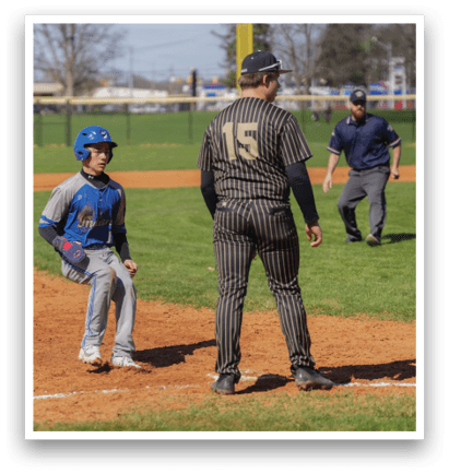A baseball game is in progress with a man in a striped shirt standing next to a boy in a blue shirt. The man is wearing a baseball glove and appears to be the umpire. AI generated content