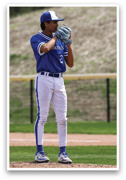 A baseball player in a blue and white uniform is standing on a pitcher's mound, holding a baseball in his hand. AI generated content