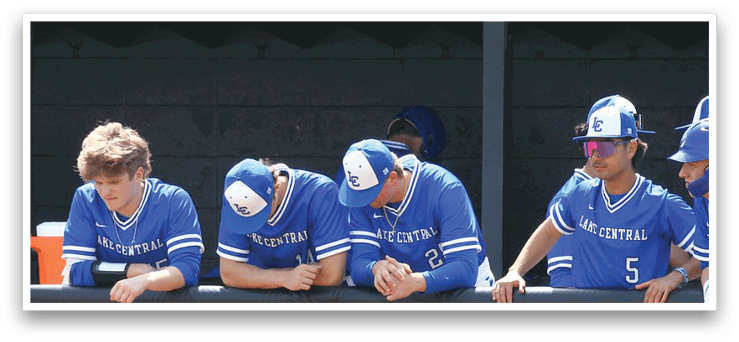 A group of baseball players wearing blue uniforms are sitting on a bench. AI generated content