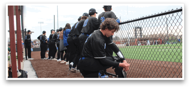 A baseball player is kneeling on the ground next to a fence. AI generated content
