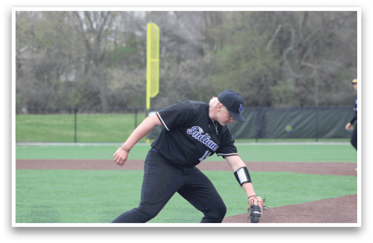 A baseball player in a black jersey is bending over to catch a ball. AI generated content