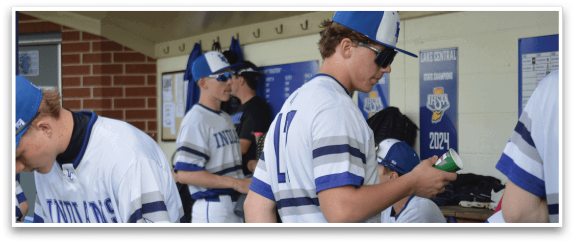 Baseball players wearing blue and white uniforms, some of them looking at their cell phones. AI generated content
