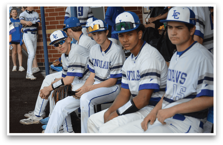 A group of baseball players wearing blue and white uniforms are sitting on a bench. AI generated content